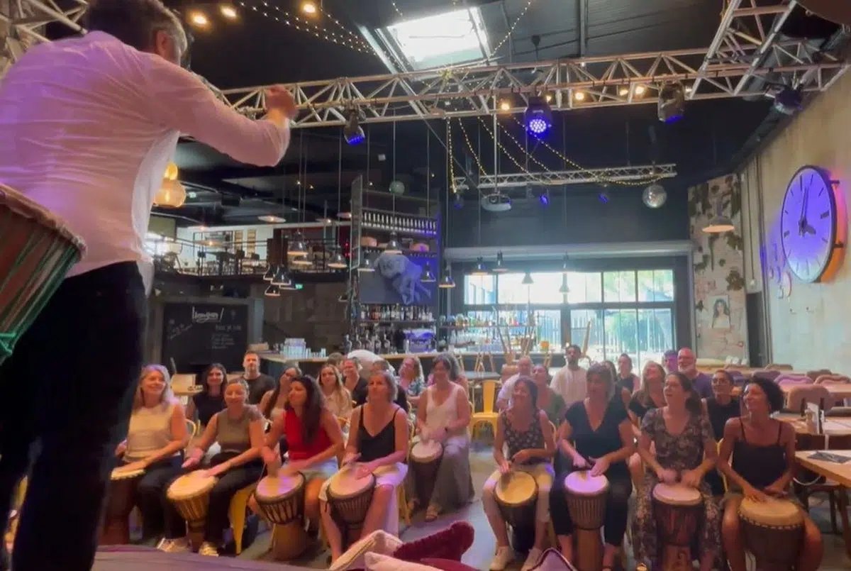 Team building djembé : des collaborateurs jouent ensemble dans un bar-restaurant